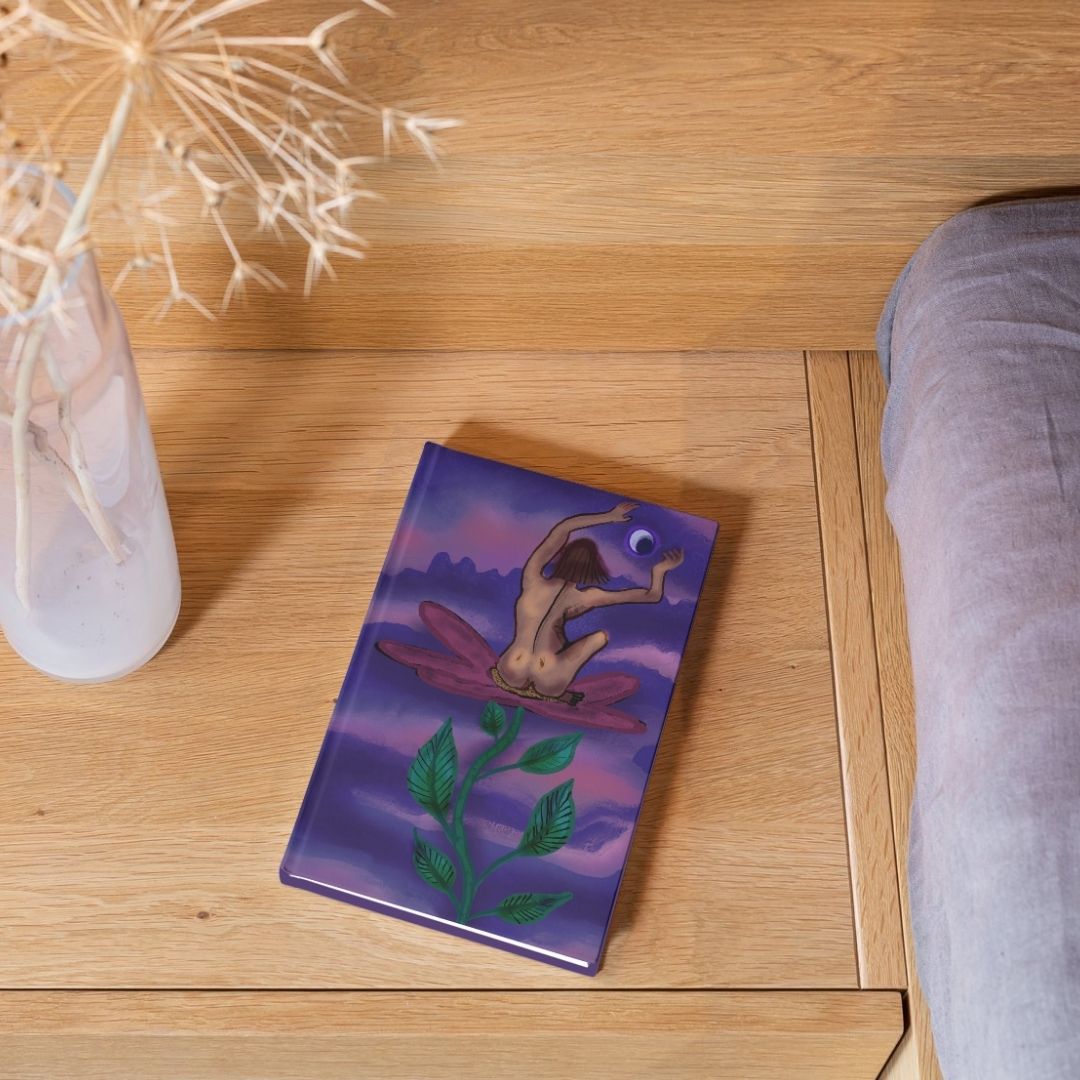 Blossom of Aether artwork printed on a hardcover journal resting on a wooden table
